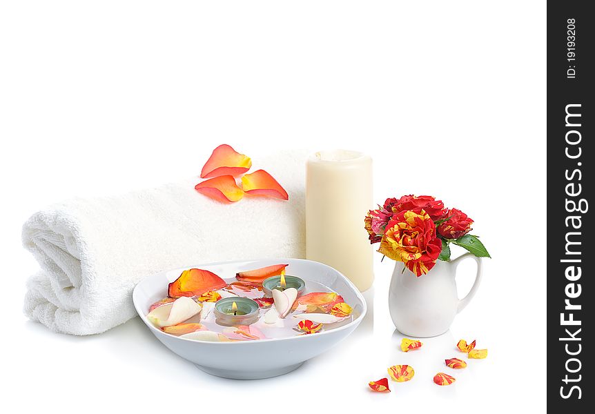 Bowl with rose petals, rose candle and towels on white background. Bowl with rose petals, rose candle and towels on white background