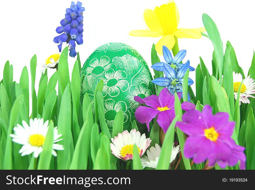 Traditional scratched hand-made Easter egg on a spring meadow