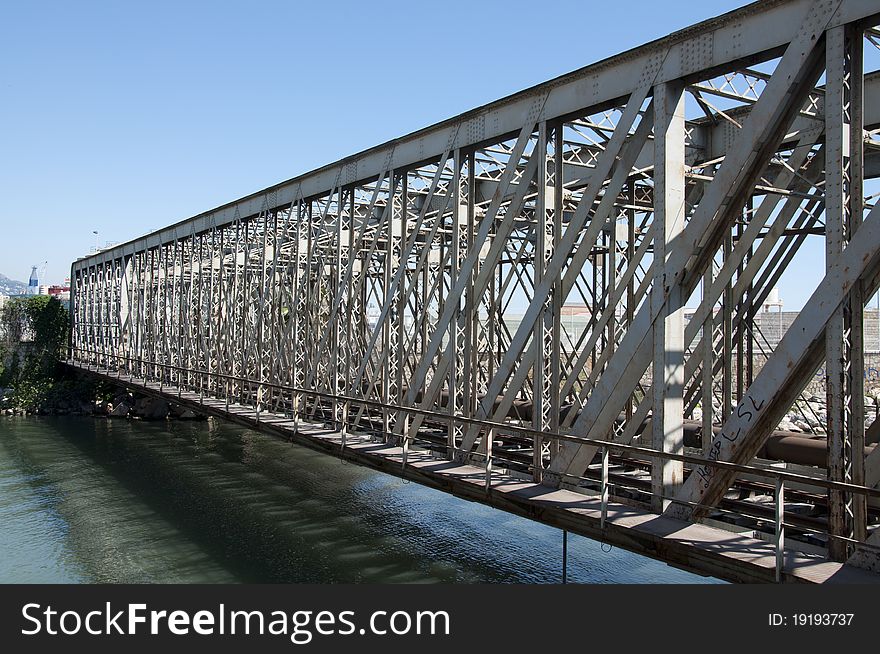 Old railway bridge over a river with a clear blue sky at Malaga, Spain.