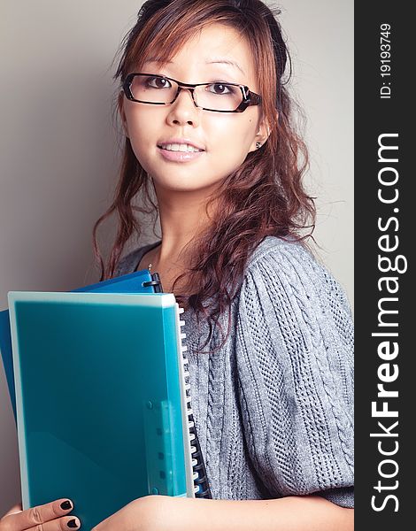 Asian girl holding a textbook. Wear glasses. Asian girl holding a textbook. Wear glasses.