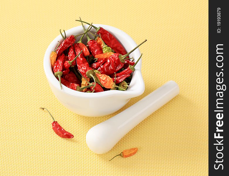 Dried chili peppers in a ceramic mortar