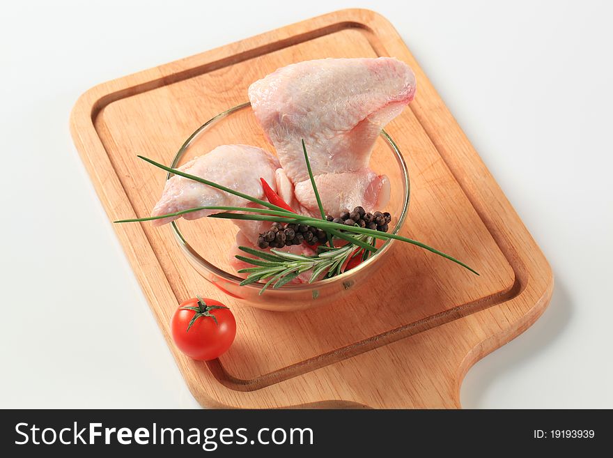 Raw chicken wings and other ingredients on cutting board