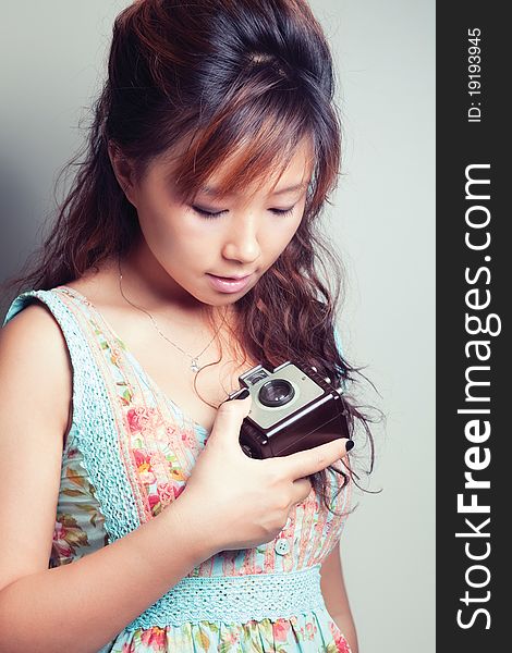 Portrait shot of a young woman holding a camera. Portrait shot of a young woman holding a camera.