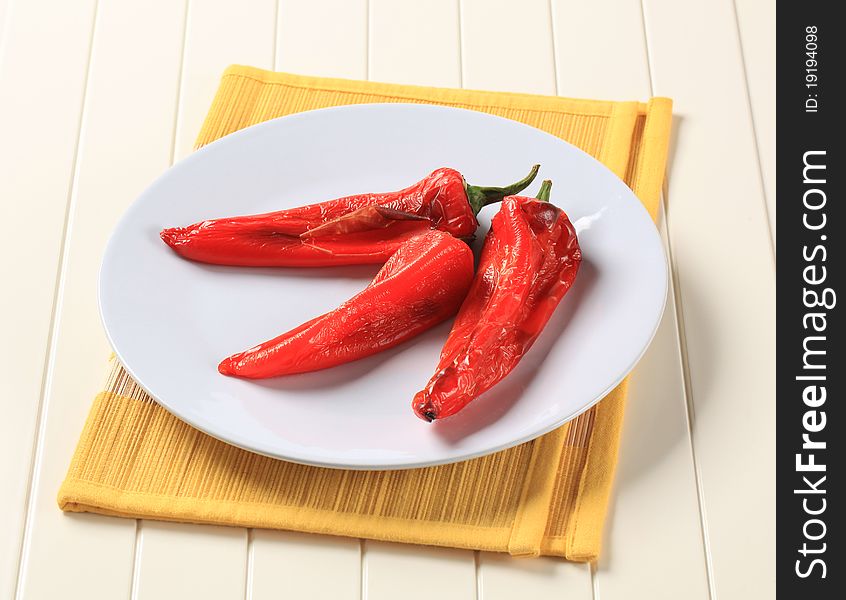 Three roasted red peppers on a plate. Three roasted red peppers on a plate