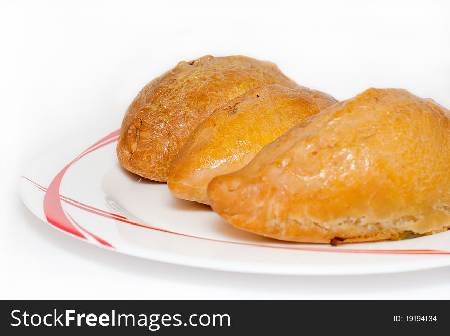 Baked pies on a white plate with red drawing