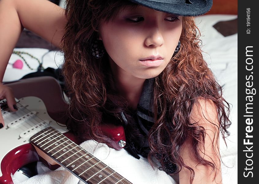 Young asian woman with a red guitar. Young asian woman with a red guitar.