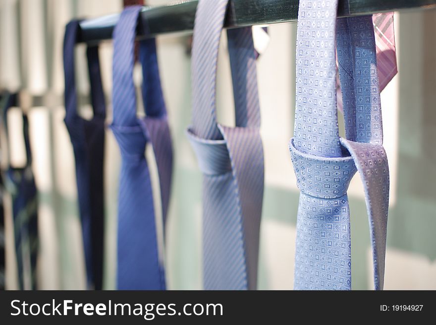Neckties hanging on the pole for sale