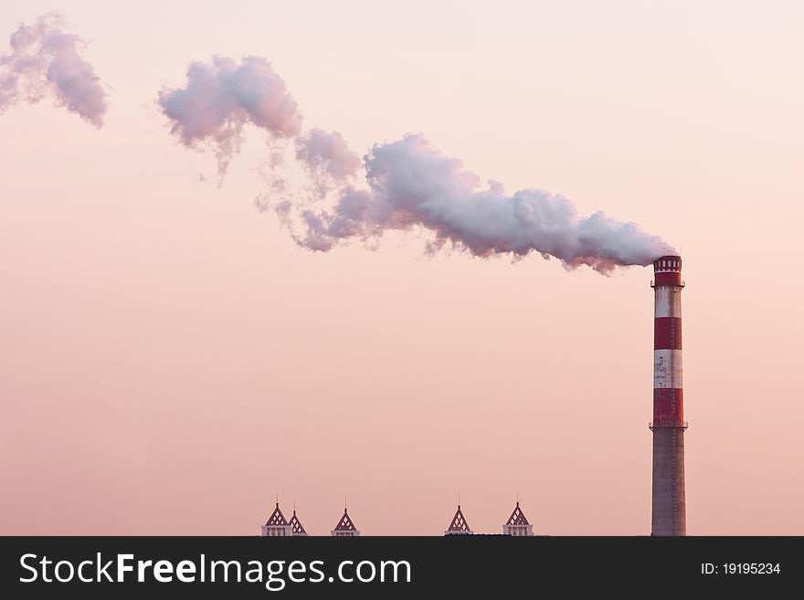 Smoking chimney in the sunset