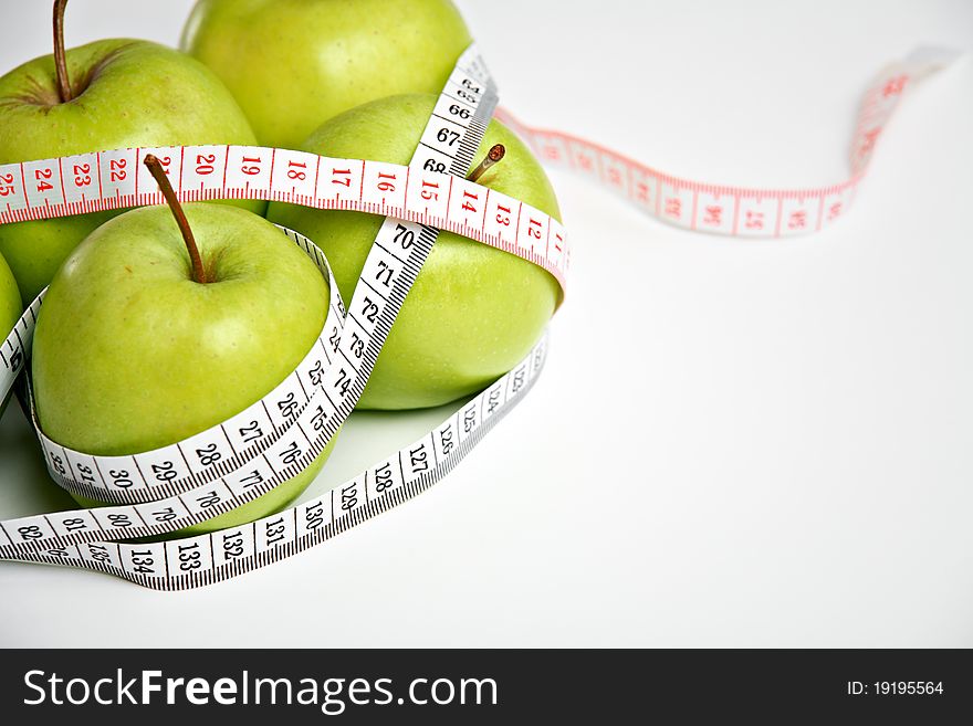 Fresh green apples with measuring tape, diet concept