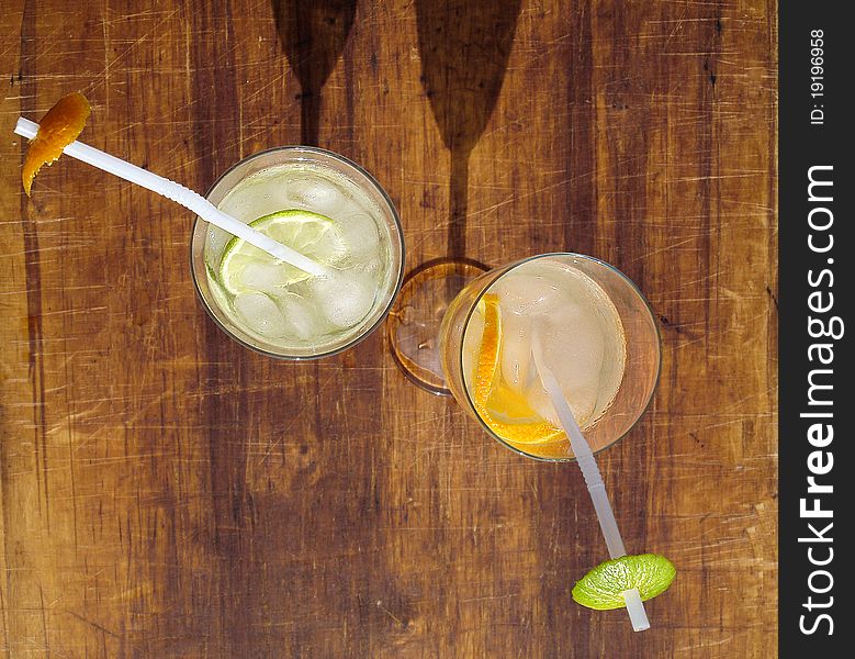 Two glasses with ice cubes, water and citrus