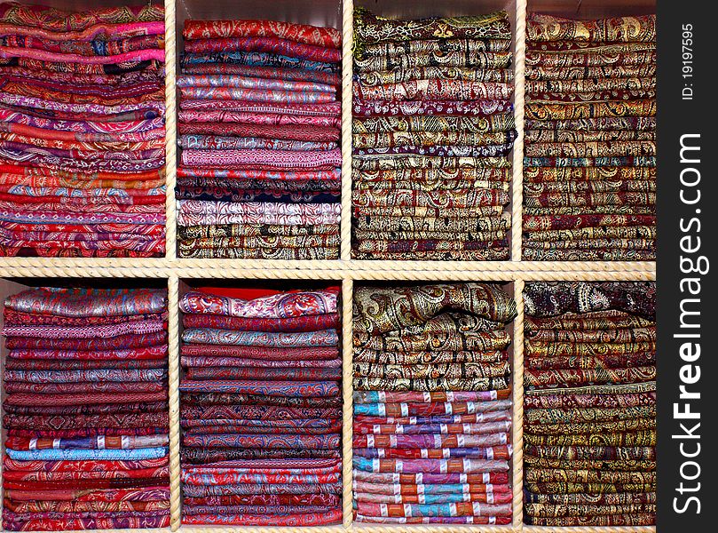 Big color palette spectrum of cotton and silk scarves on shelves front view. Big color palette spectrum of cotton and silk scarves on shelves front view