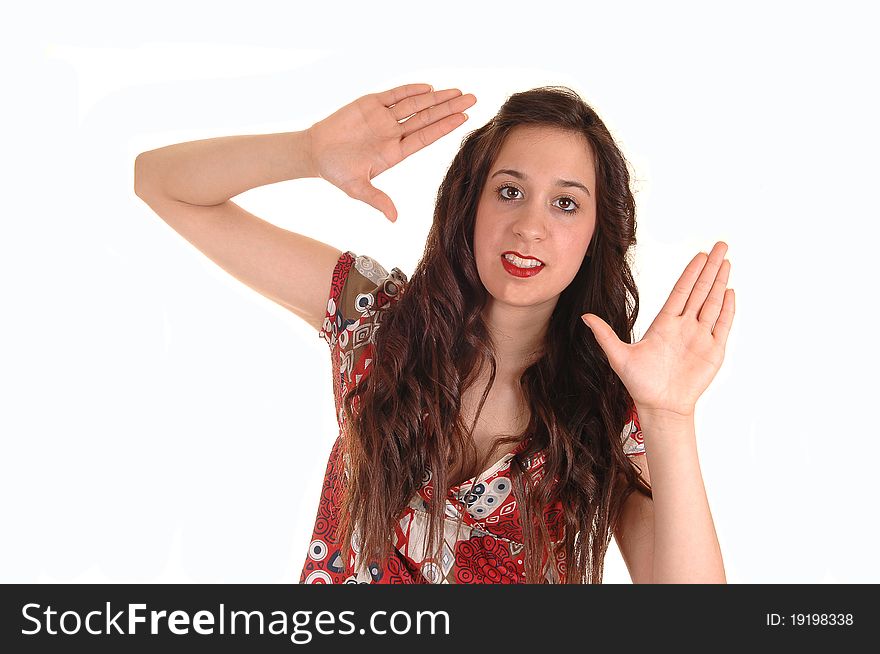 A young lovely woman giving a sign for taking a picture in a colorful dress and long hair, over white background. A young lovely woman giving a sign for taking a picture in a colorful dress and long hair, over white background.