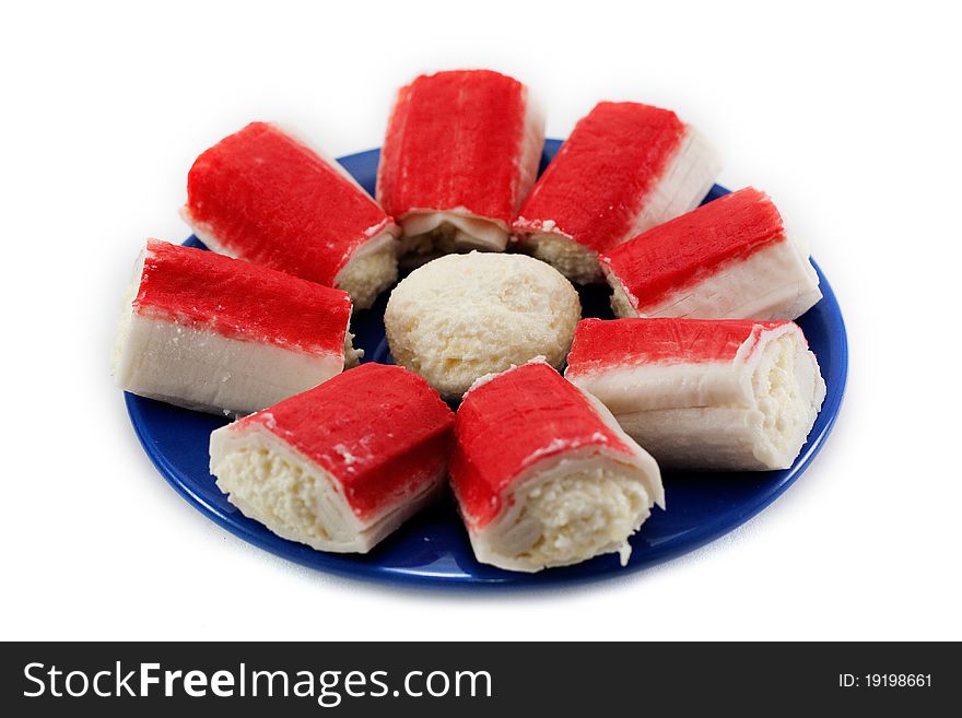 A dish of crab sticks on the blue plate isolated on white background. A dish of crab sticks on the blue plate isolated on white background