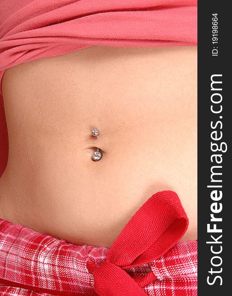 An nice belly of a young woman in an pink pyjama showing her belly button with the jewelery in, in closeup. An nice belly of a young woman in an pink pyjama showing her belly button with the jewelery in, in closeup.