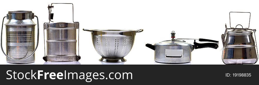 Steel utensils pressure cooker, tiffin box, milk can nd fruit bowl isolated on white background.