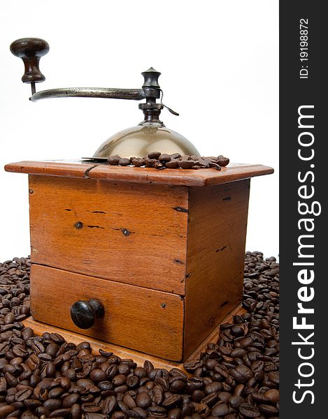 Old fashion coffee grinder against a white background with coffeebeans. Old fashion coffee grinder against a white background with coffeebeans