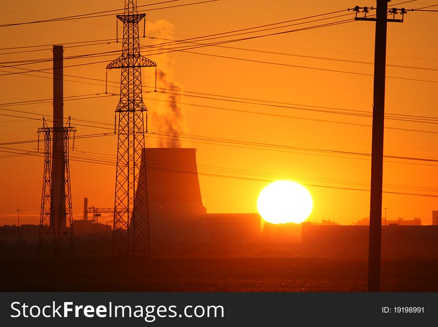 Big disk of setting sun above industrial landscape. Big disk of setting sun above industrial landscape