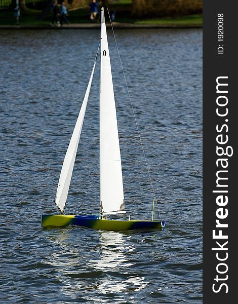 Model yacht being sailed upon a lake. Model yacht being sailed upon a lake