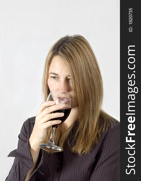 A thoughtful woman drinks a glass of red wine