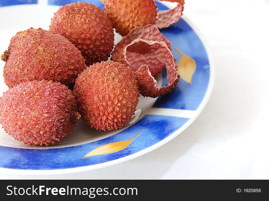 Lychees on a plate isolated against white background
