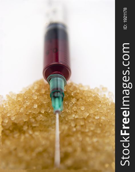 Blood filled hypodermic syringe on brown crystal foreground. Blood filled hypodermic syringe on brown crystal foreground