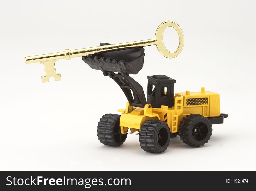 Toy earth-mover holding up key. Toy earth-mover holding up key
