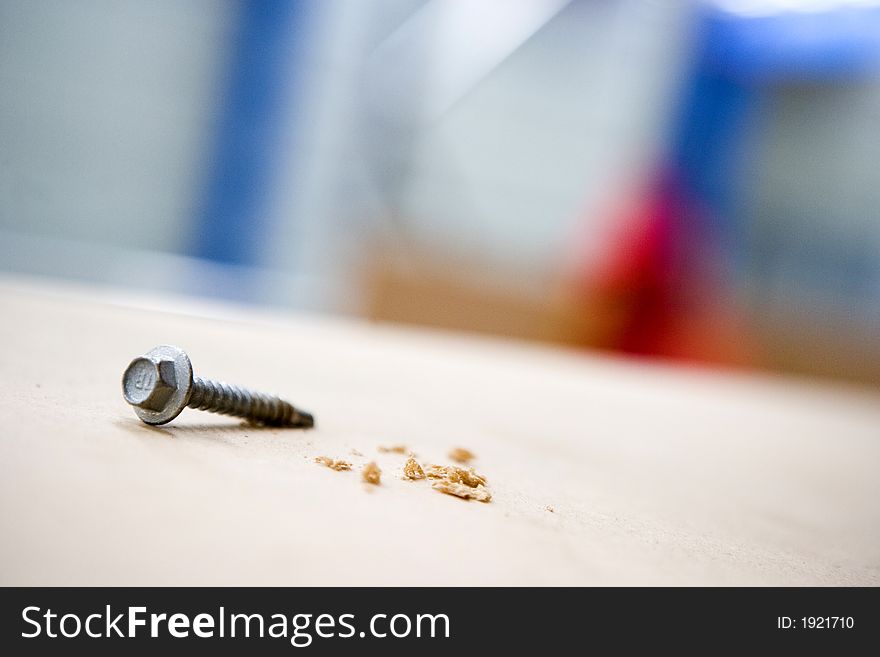 Screw on shelf with sawdust beautiful colors in background