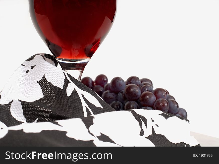 Low view of a wine glass with wine and grapes and napkin