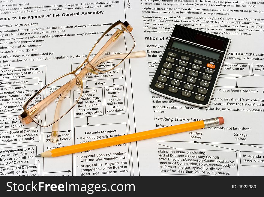 Glasses, pencil and calculator on business background