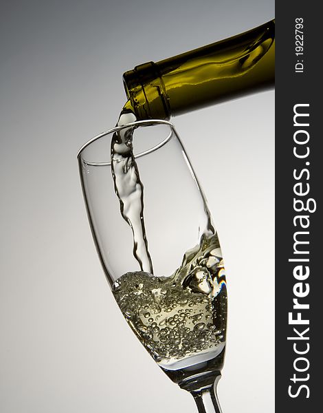 White wine pouring into a wineglass. White wine pouring into a wineglass