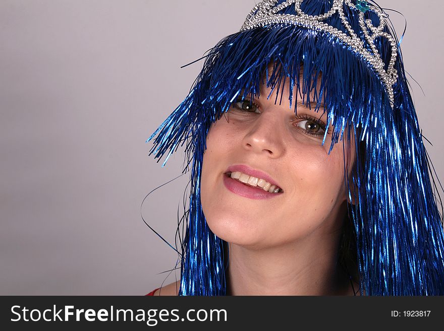 A young woman ready for carnival with blue hair and a crown. A young woman ready for carnival with blue hair and a crown.