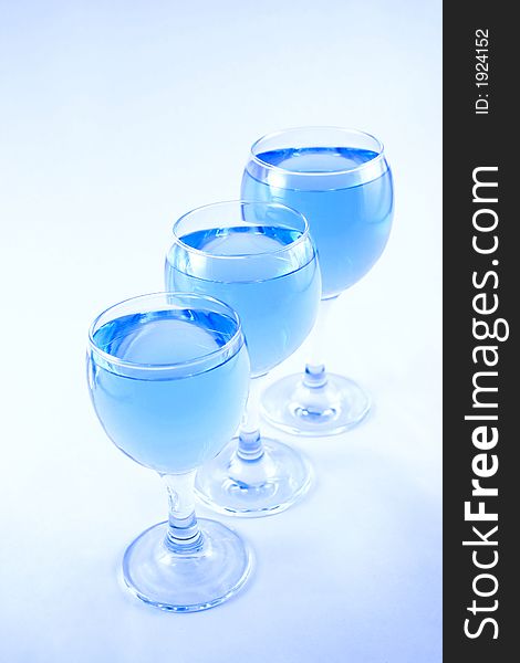 Glasses with a blue liquid on a white background