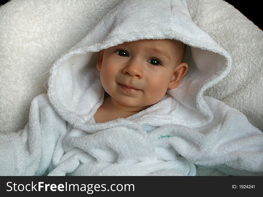 The baby of 7 months in sits in a dressing gown. The baby of 7 months in sits in a dressing gown