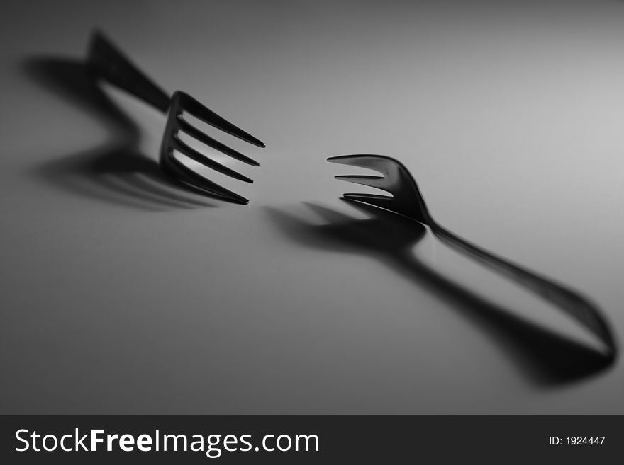 Two forks and their shadows.