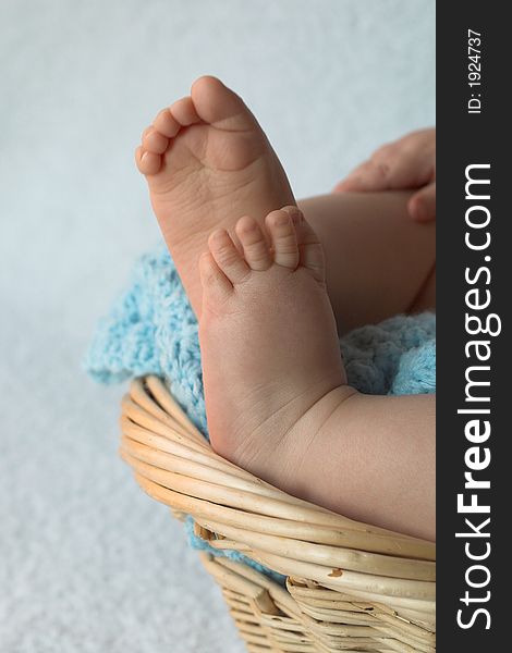 Image of baby feet peeking over the side of a blanket-lined basket