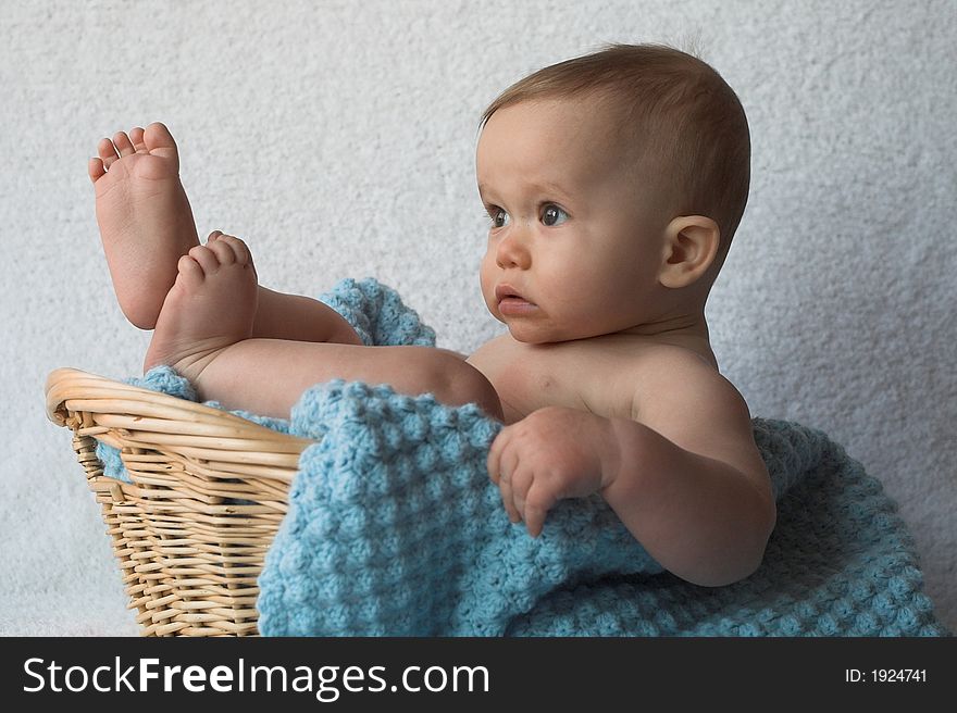 Image of baby sitting in a basket. Image of baby sitting in a basket