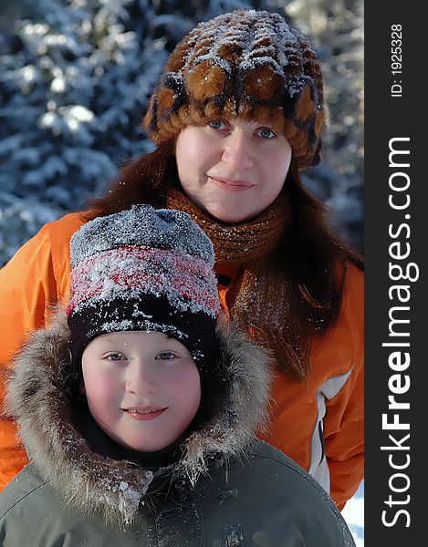 Portrait of mother and son in winter clothes and hats covered with snow taken in sunny , cold , winter day. Portrait of mother and son in winter clothes and hats covered with snow taken in sunny , cold , winter day