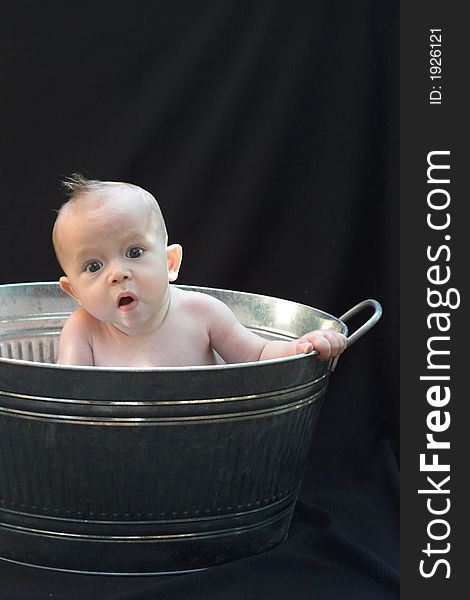 Image of baby sitting in a galvanized tub. Image of baby sitting in a galvanized tub