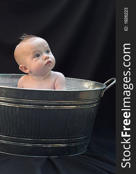 Image of baby sitting in a galvanized tub. Image of baby sitting in a galvanized tub