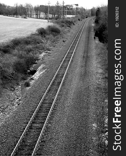 A black and white image of country railroad tracks.