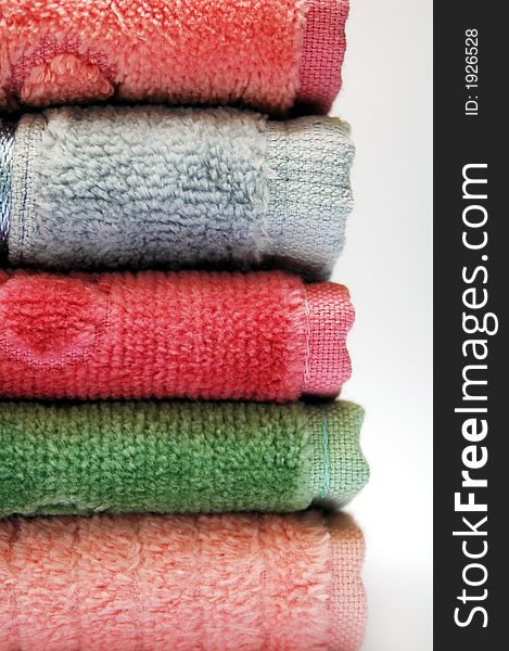 Bath towels of different colours piled on top of one another. Bath towels of different colours piled on top of one another