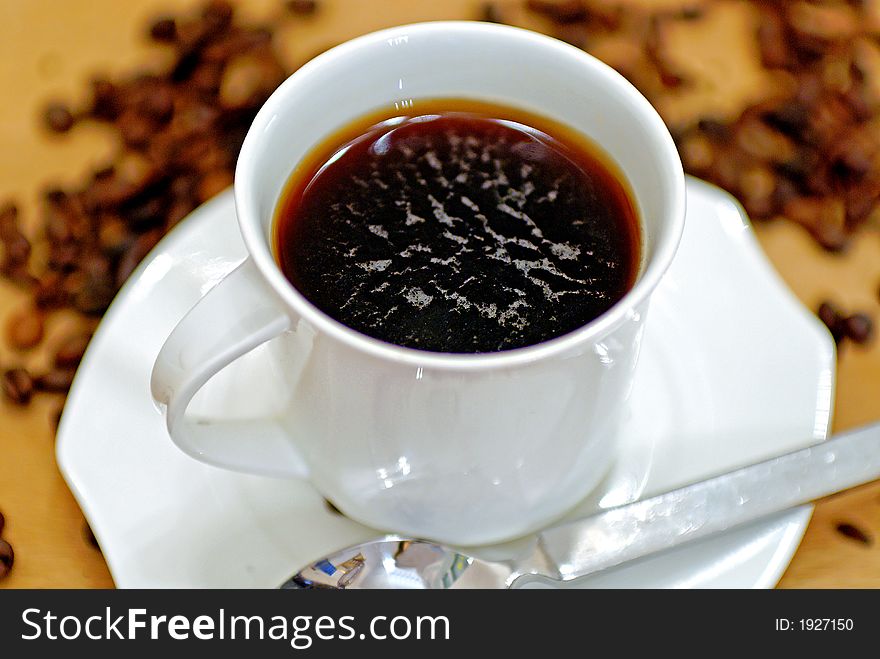 A pot of coffee on a wooden table. A pot of coffee on a wooden table