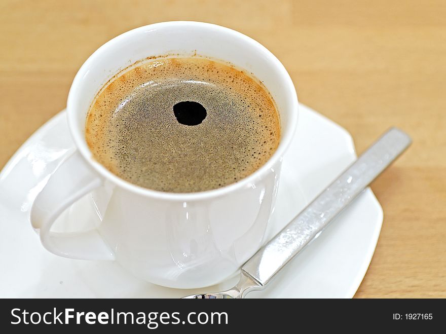 A pot of coffee on a wooden table. A pot of coffee on a wooden table