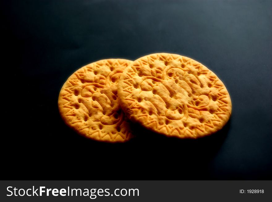 Two biscuits isolated on black background