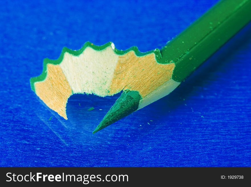 Green pencil over blue background. Green pencil over blue background