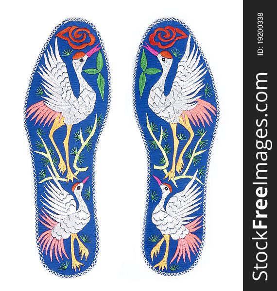 Handmade colorful insoles with crane designs, isolated on white. Handmade colorful insoles with crane designs, isolated on white.