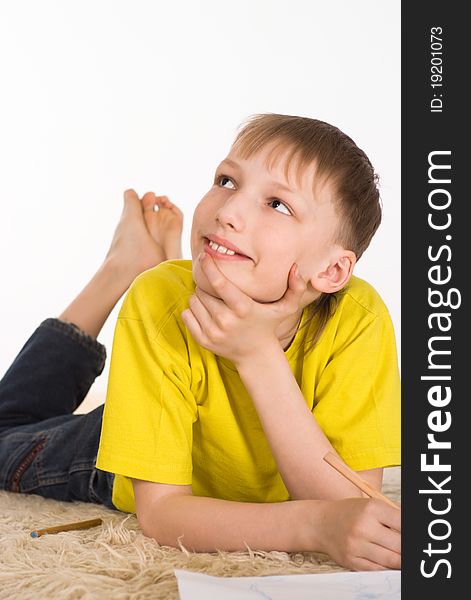 Young boy drawing on the carpet on white