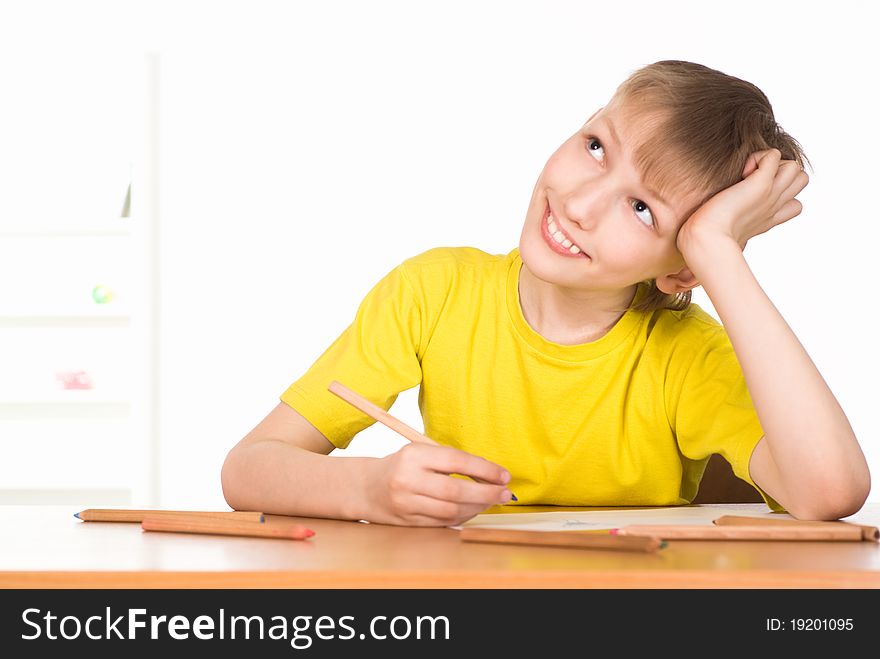 Young boy drawing at the table on white. Young boy drawing at the table on white