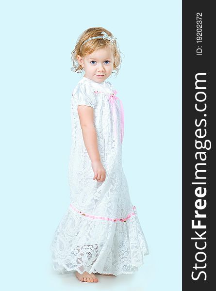 Portrait of pretty girl wearing traditional laced dress for first communion isolated on blue background. Portrait of pretty girl wearing traditional laced dress for first communion isolated on blue background