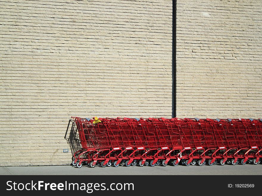 Shopping carts against a wall in the sun